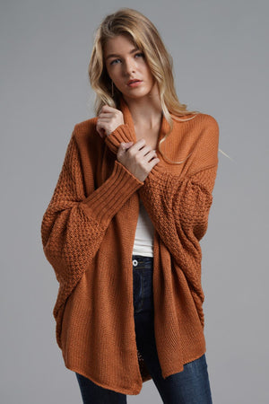 Woman wearing a chic open front ribbed trim longline cardigan in rust color, styled for a casual look.