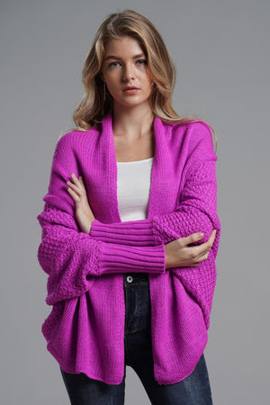 Stylish model wearing a vibrant pink dolman sleeve open front cardigan with ribbed details.