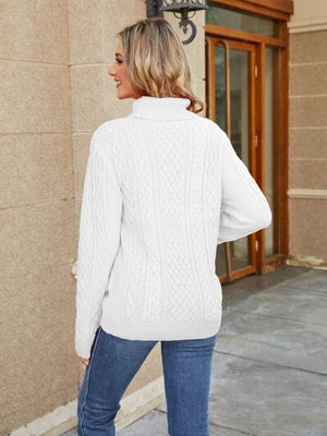 Stylish woman wearing a white cable-knit mock neck sweater from the back in a cozy outdoor setting.