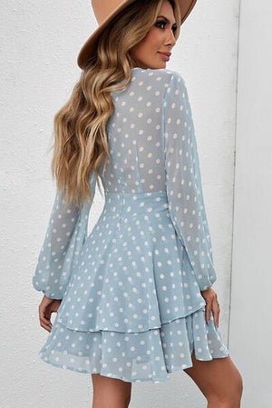 Back view of a light blue polka dot balloon sleeve dress with a layered skirt, styled with a matching hat.