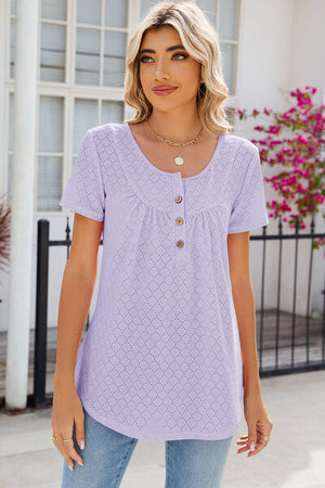 Light purple eyelet buttoned short sleeve t-shirt displayed on a model against a floral backdrop.