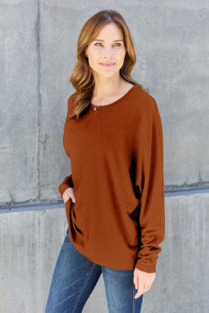 Model wearing a brown Double Take full size round neck long sleeve T-shirt paired with jeans, showcasing a casual look.