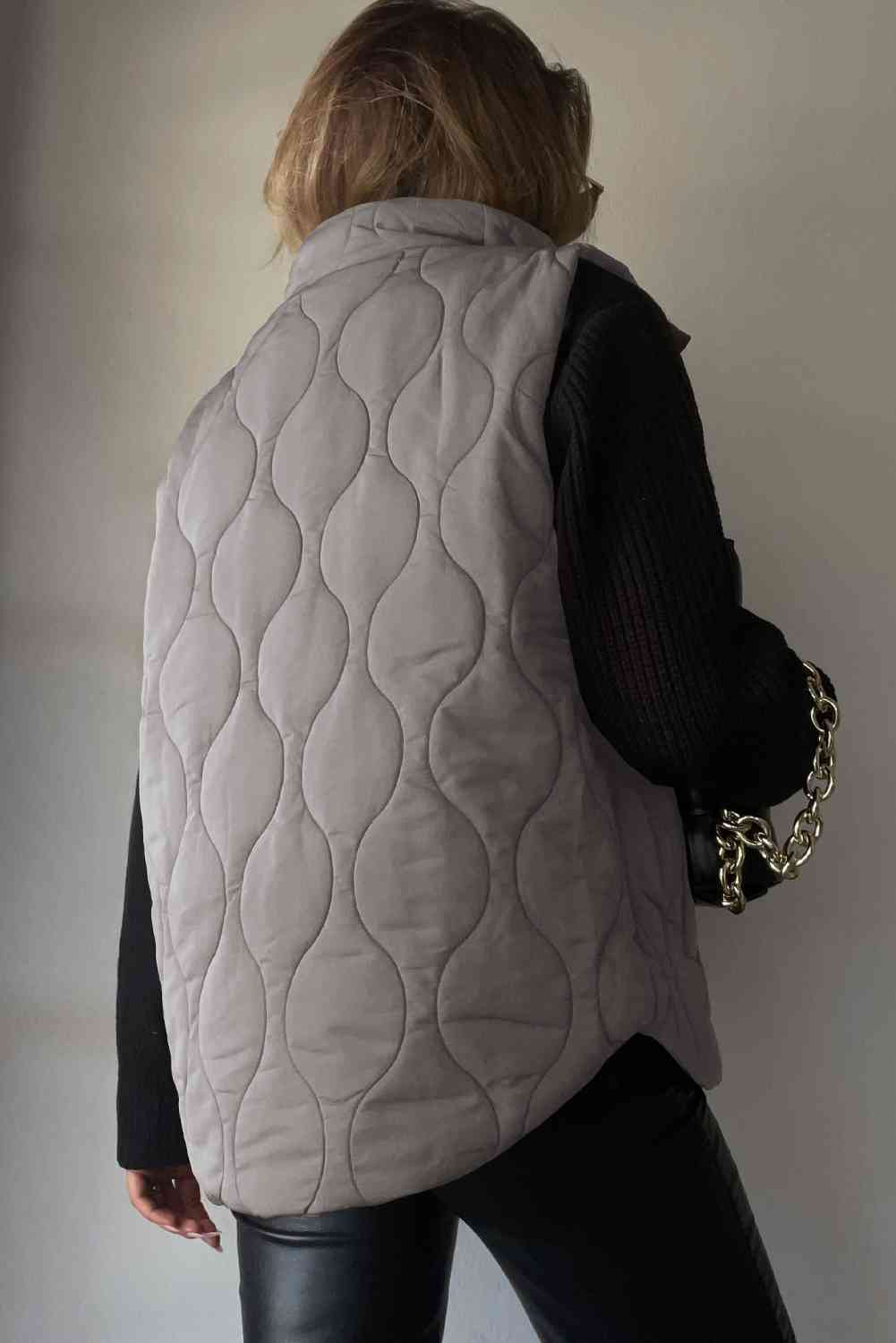 Back view of a collared neck vest with pockets in grey, featuring a quilted design and stylish look.