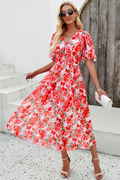 Smocked printed V-neck short sleeve dress in vibrant floral design, perfect for summer occasions.