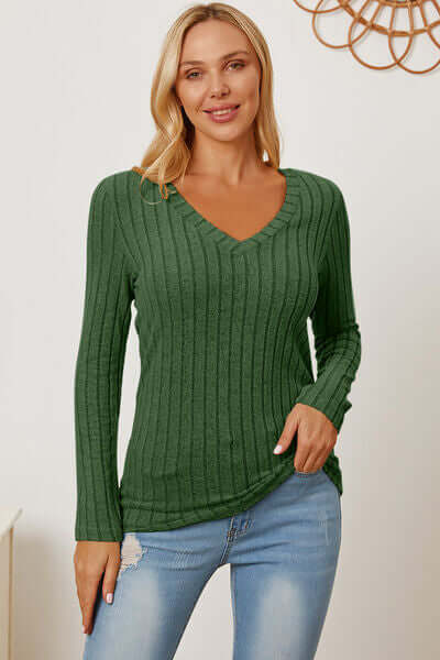Model wearing a green ribbed V-neck long sleeve t-shirt paired with denim jeans, showcasing a casual and stylish look.