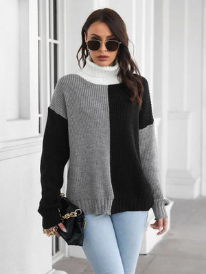 Women’s contrast turtleneck long sleeve sweater in black and grey, paired with light blue jeans and accessories.