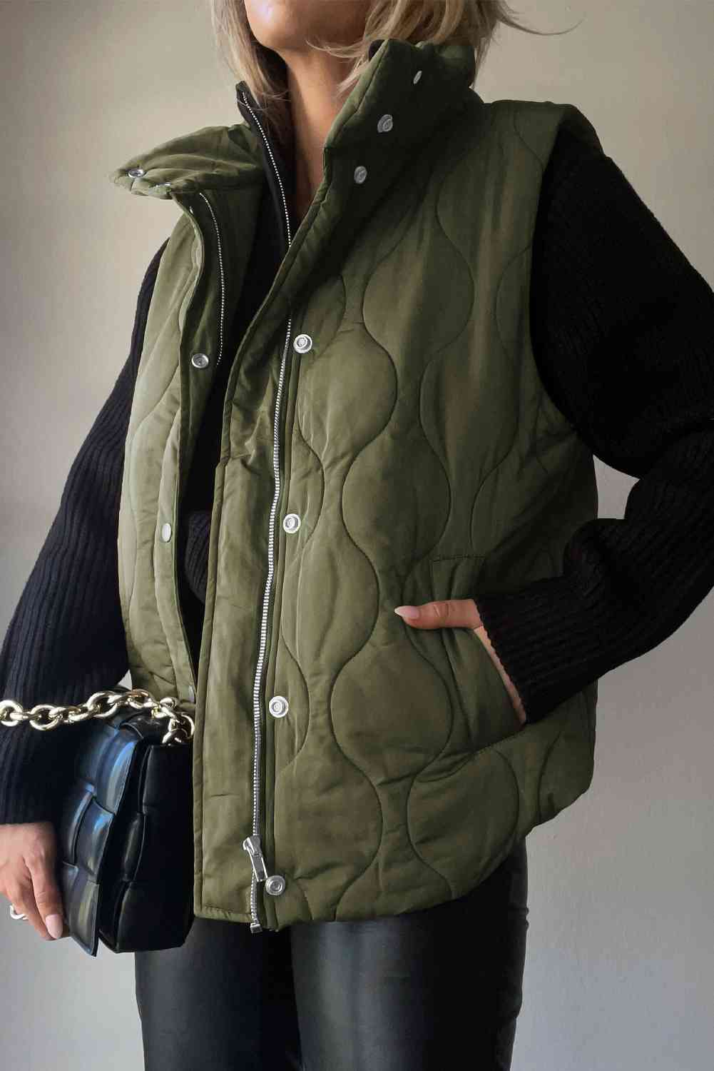 Stylish collared neck vest in olive green with pockets, paired with a black sweater and handbag.