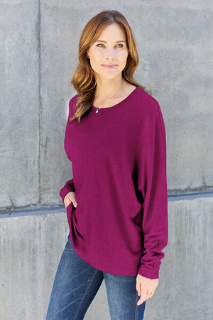 Model wearing a purple double take full size round neck long sleeve t-shirt, styled with blue jeans.