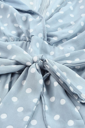 Close-up of the tied waist detail on a blue polka dot balloon sleeve dress in sheer fabric.