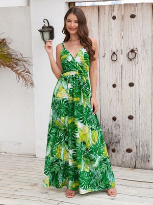 Model wearing a Printed Surplice Spaghetti Strap Dress with a vibrant green leaf pattern, perfect for summer outings.