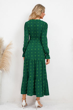 Back view of a green Swiss dot tied surplice flounce sleeve dress, showcasing tiered skirt and elegant design.