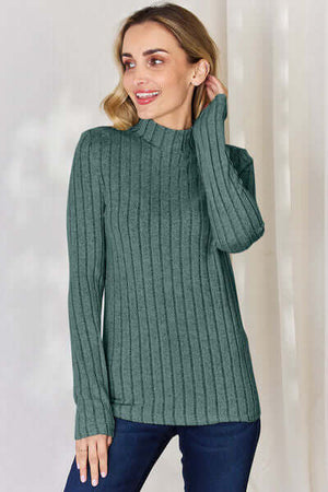 Model wearing a green ribbed mock neck long sleeve t-shirt, showcasing its stylish and comfortable design.