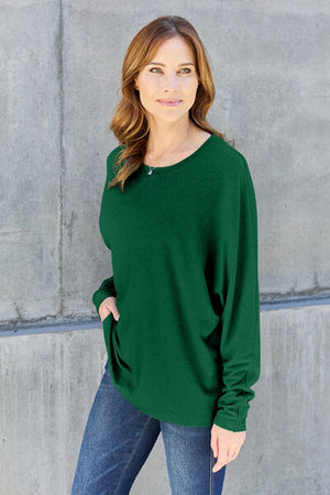 Model wearing a green long sleeve round neck t-shirt, showcasing a relaxed fit and casual style.
