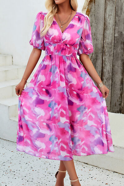 Smocked printed V-neck short sleeve dress in pink watercolor print, perfect for summer occasions.