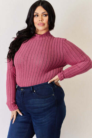 Model wearing Basic Bae full size ribbed mock neck long sleeve T-shirt in pink with jeans, showcasing a stylish look.