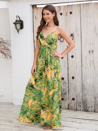 Model showcasing a printed surplice spaghetti strap dress with a vibrant green and yellow leaf pattern.
