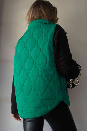 Back view of a green collared neck vest with a quilted pattern, paired with a black outfit.