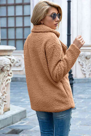 Back view of a woman in a casual, cozy full size lapel collar sherpa coat, showing stylish urban fashion.