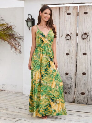 Model wearing a vibrant printed surplice spaghetti strap dress with a tropical leaf pattern, perfect for summer outings.