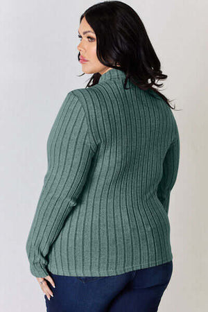 Plus-size model wearing a green ribbed mock neck long sleeve t-shirt, showcasing the back design.