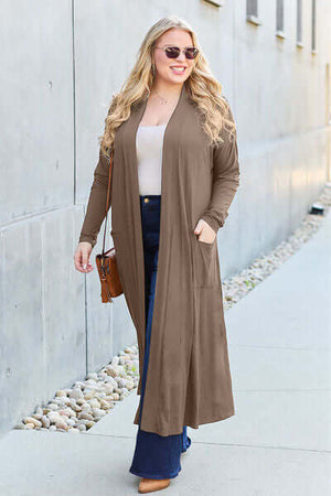 Stylish woman wearing a pocketed open front long sleeve cover-up in brown, perfect for casual outings.