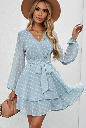 Tied layered polka dot dress with balloon sleeves, styled with a hat and handbag, perfect for casual outings.
