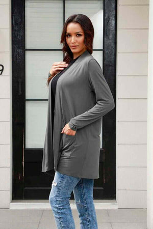 Woman modeling a Basic Bae long sleeve cardigan with pockets in gray, paired with jeans.