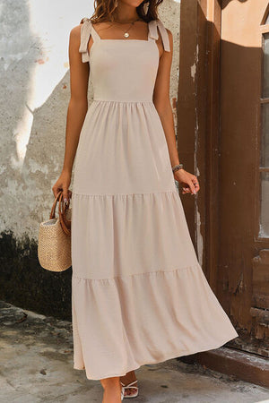 Elegant tie shoulder smocked tiered dress in light beige, perfect for summer outings and casual events.