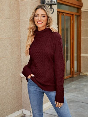 Model wearing a burgundy cable-knit mock neck sweater paired with jeans, showcasing a trendy fall outfit.