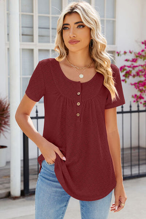 Model wearing a burgundy eyelet quarter button short sleeve t-shirt with a rounded neckline and casual look.