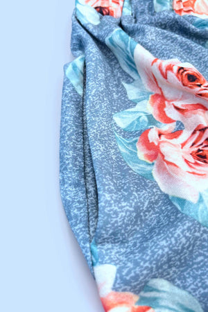 Close-up of a floral-print fabric featuring roses on a textured light blue background.