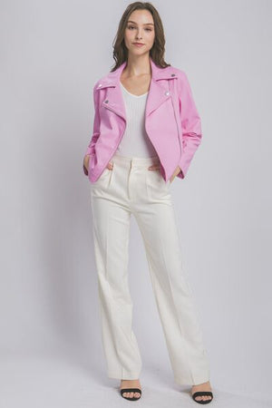 Stylish model wearing LOVE TREE pink collared neck zip up jacket with white pants and heels.
