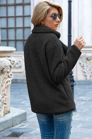 Woman wearing a full-size lapel collar sherpa coat in urban setting, showcasing its casual style and double-breasted design.