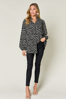 Elegant woman in double take leopard long sleeve blouse paired with black skinny jeans, showcasing a stylish, chic look.