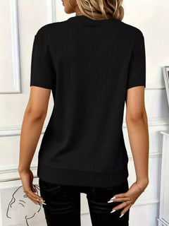 Back view of the Half Zip Short Sleeve Top in black ribbed fabric, showcasing its slightly stretchy material.