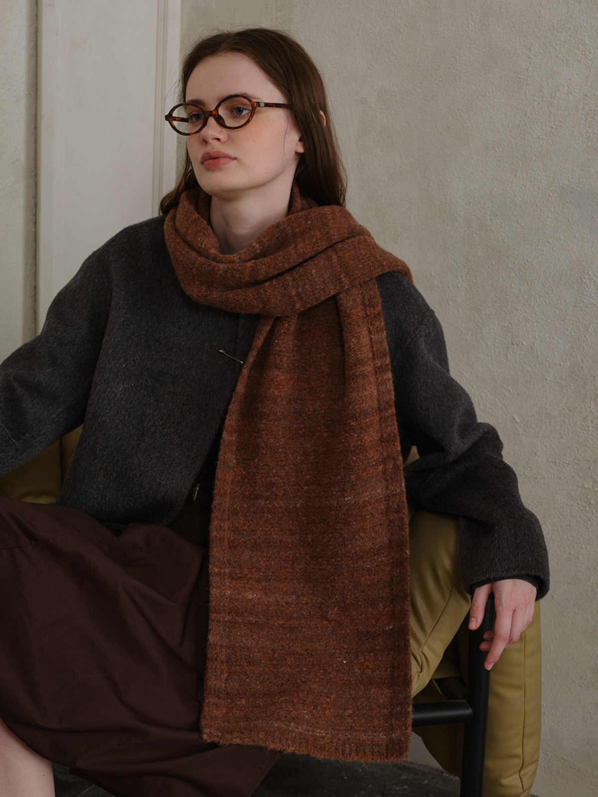 Model wearing a stylish striped detail knit scarf in brown tones, showcasing cozy fashion for fall and winter.
