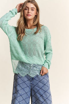 Model wearing mint green lace detail long sleeve knit top with stylish blue wide-leg pants.