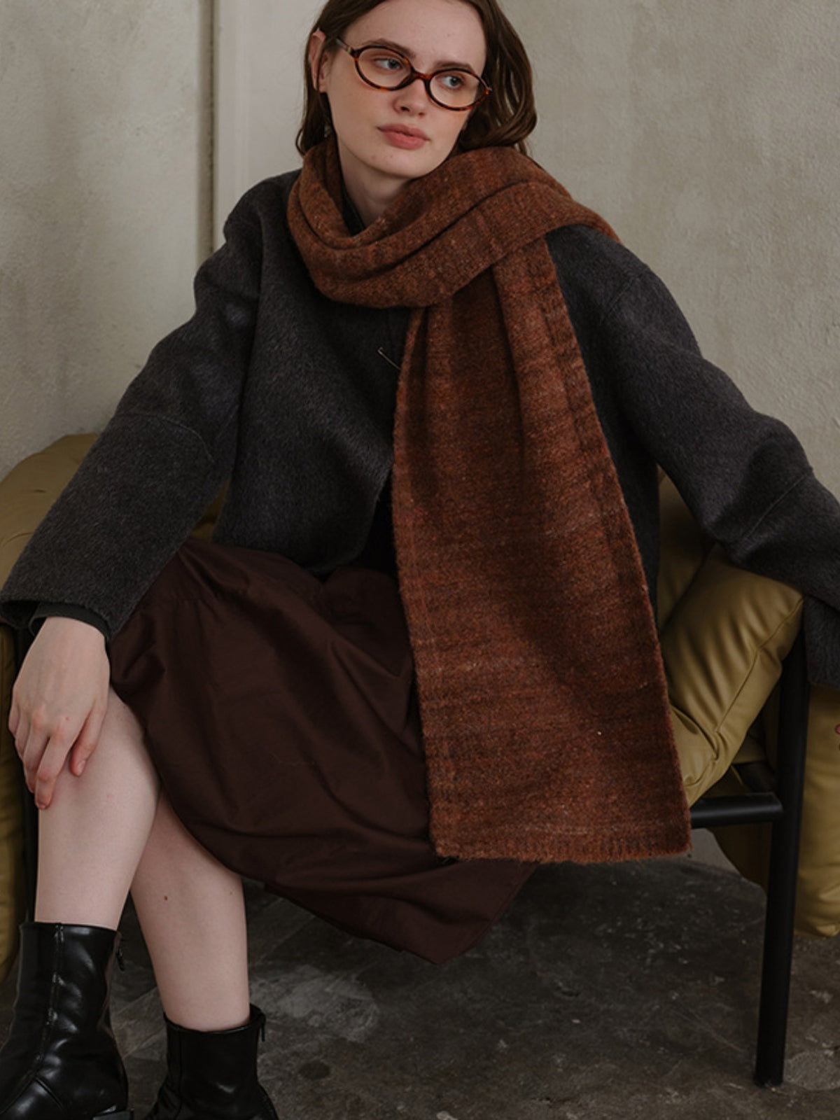 Model wearing a striped detail knit scarf made from fur, showcasing its cozy texture and elegant style.