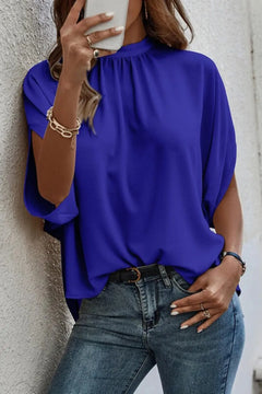 Model wearing a Tie Back Slit Half Sleeve Blouse in vibrant blue, showcasing its stylish design and relaxed fit.