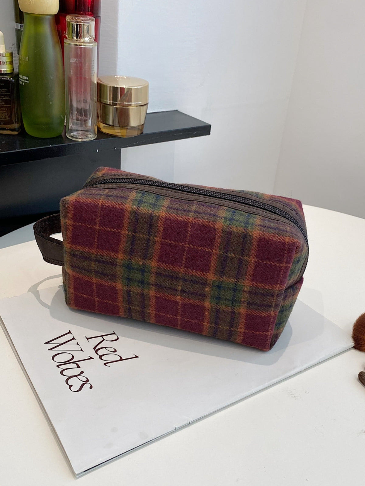 Small contrast plaid clutch bag with zipper, made of polyester, featuring stylish geometric patterns in rich colors.