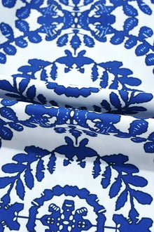 Close-up of vibrant blue floral print fabric on a white background, ideal for stylish printed crew neck sleeveless tops.