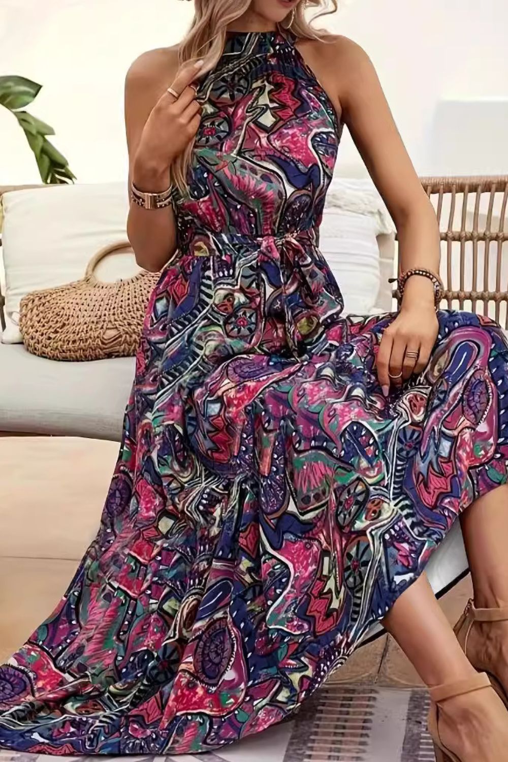 Colorful tied slit floral sleeveless dress displayed on a model in a stylish indoor setting.