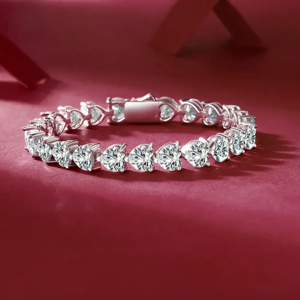24 Carat Moissanite Heart Bracelet in 925 Sterling Silver, elegant jewelry piece with sparkling stones displayed on red background.