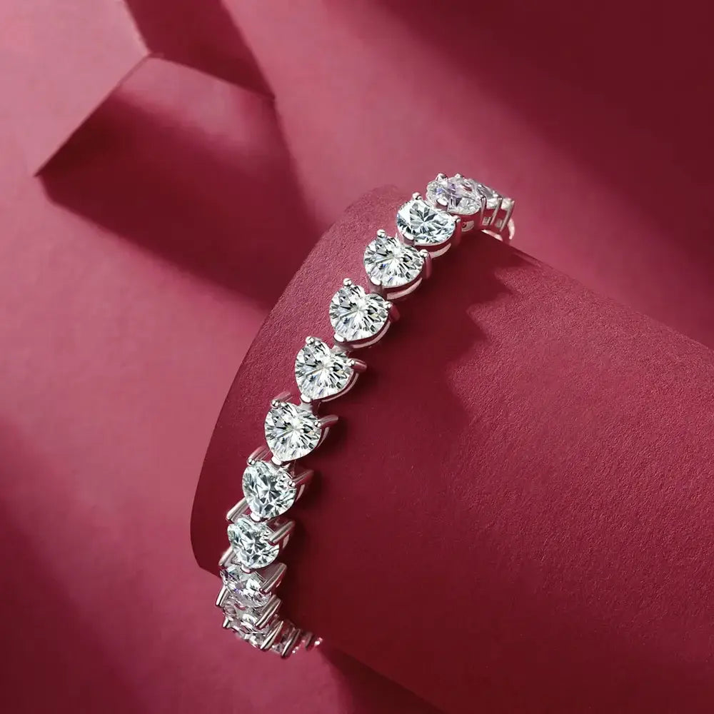 24 Carat Moissanite 925 Sterling Silver heart bracelet, showcasing sparkling stones on a deep burgundy background.
