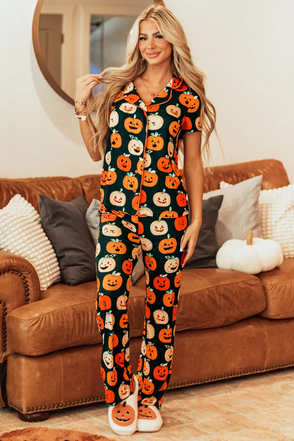 Model wearing a pumpkin printed short sleeve top and pants lounge set, styled cozily on a couch.