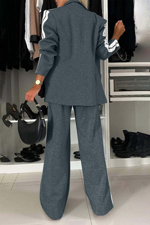 Back view of a woman in a full-size contrast lapel collar top and pants set in grey with white stripes.