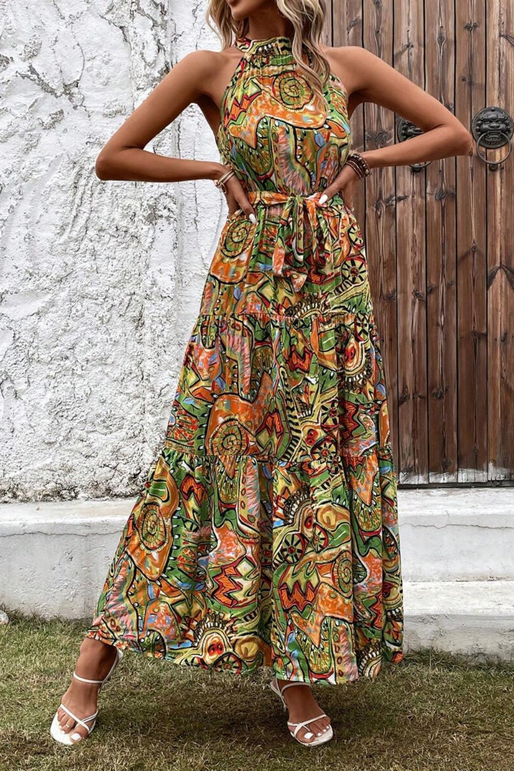 Tied slit floral sleeveless dress featuring vibrant colors and a stylish halter neck for a chic summer look.