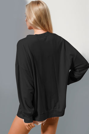 Back view of a woman wearing a black oversized long sleeve sweatshirt with a round neck.