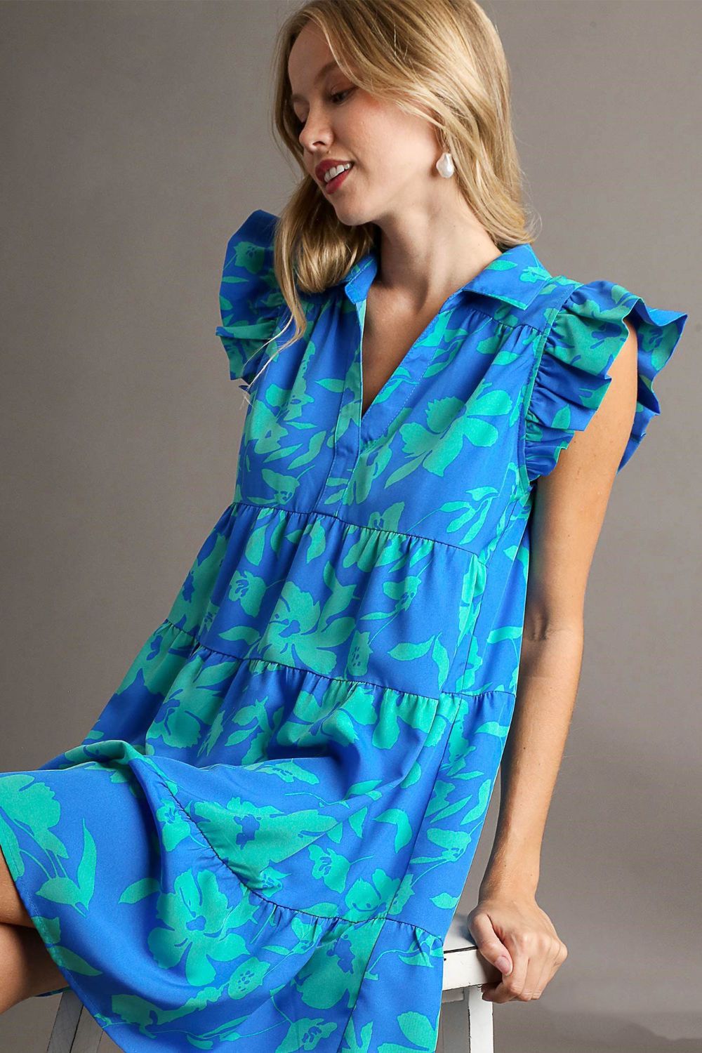 Woman wearing Umgee Plus Size Floral Ruffle Tiered Dress with cap sleeves and floral print in blue and green.