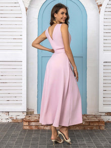 Model wearing a pink full size slit V-neck sleeveless midi dress, showcasing an elegant back view.